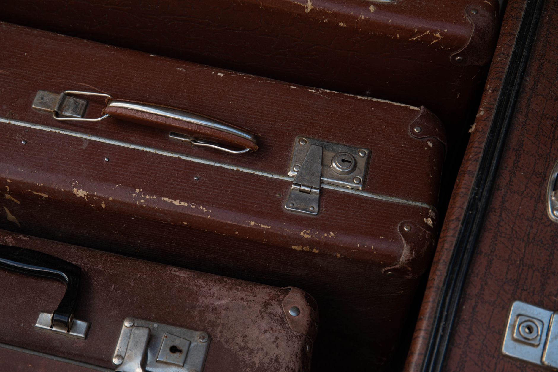 Valise usée vide, symbole du déracinement et des voyages forcés