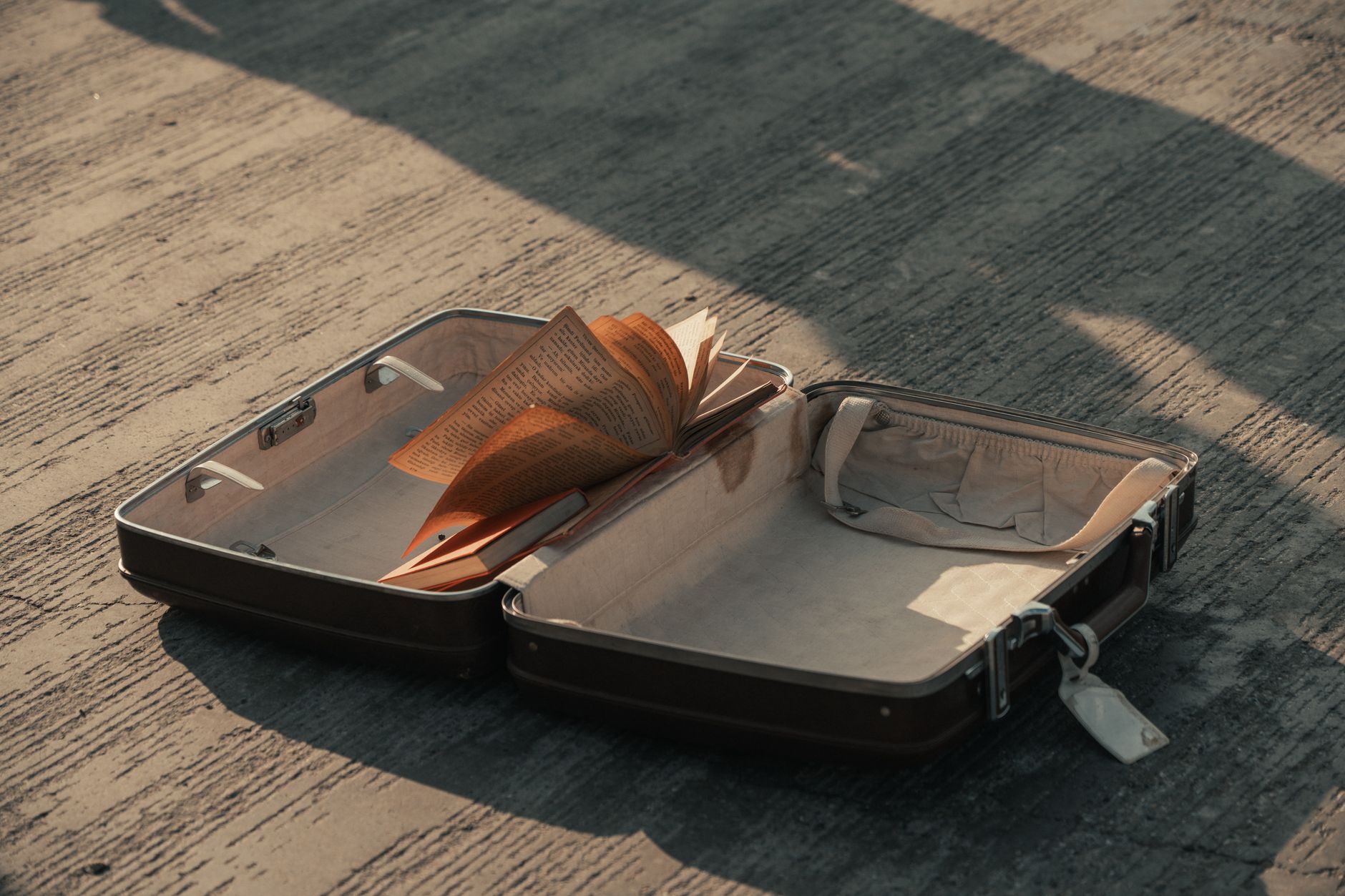 Une valise vide abandonnée symbolisant le départ et la perte
